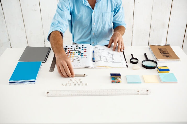 Brand designer planning a logo redesign with color palette and branding materials