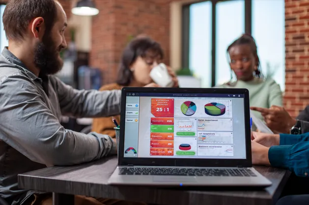Business team analyzing sales performance dashboard together