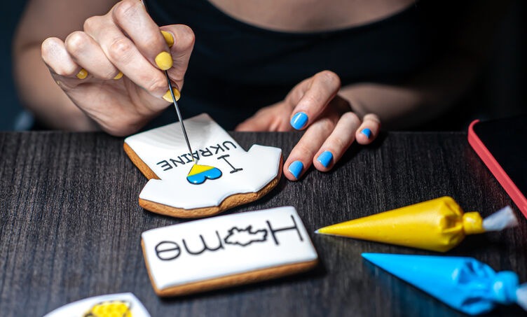 Designer decorating branded cookies as part of a creative branding project